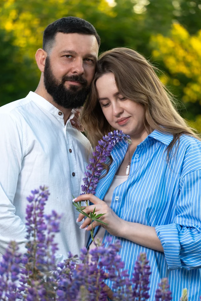 Парная фотосессия на природе: пара позирует в окружении лаванды в парке, создавая теплую и романтичную атмосферу.